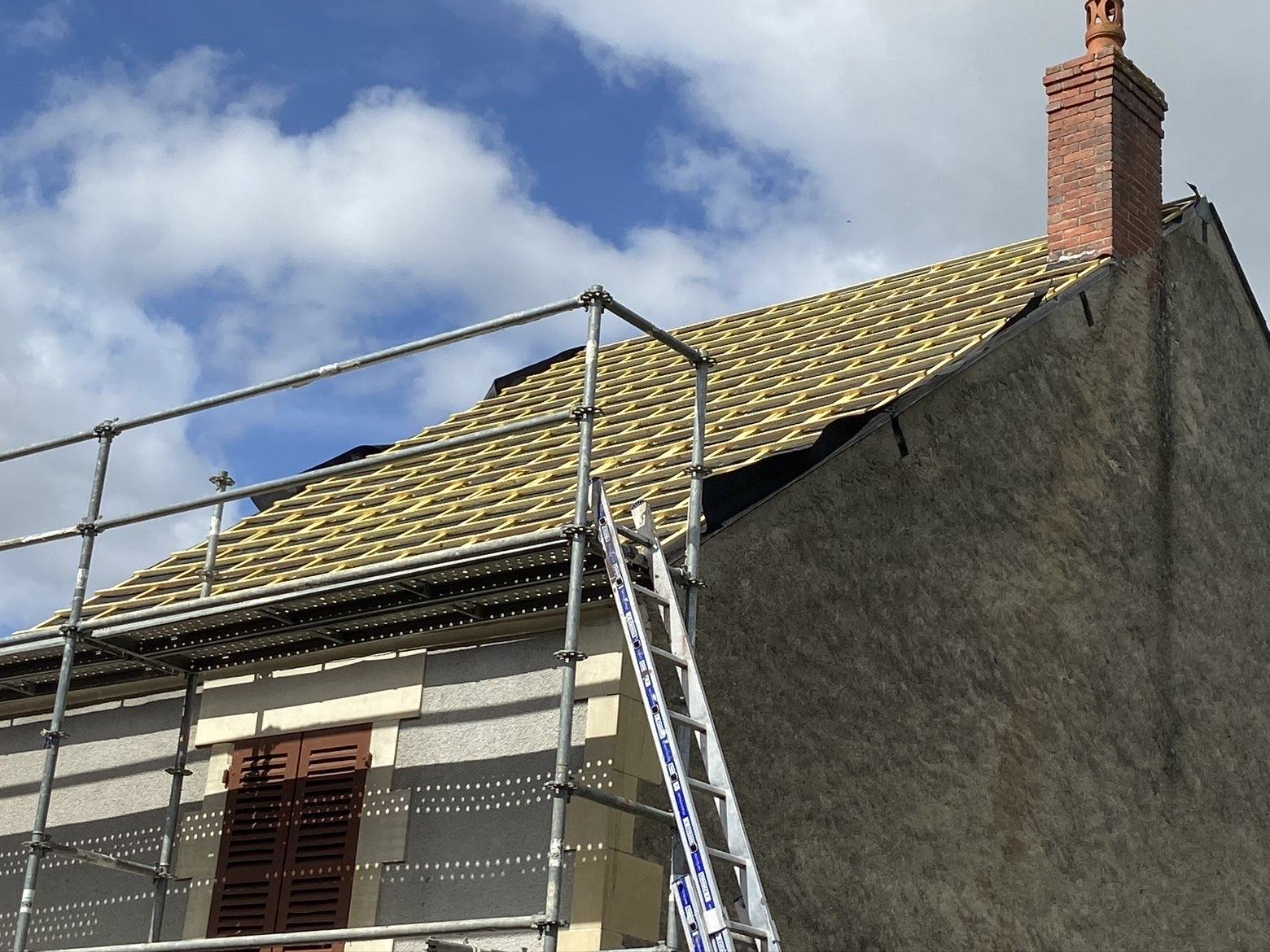 Liteaunage neuf et échafaudage sur le pignon d’une maison en pierre